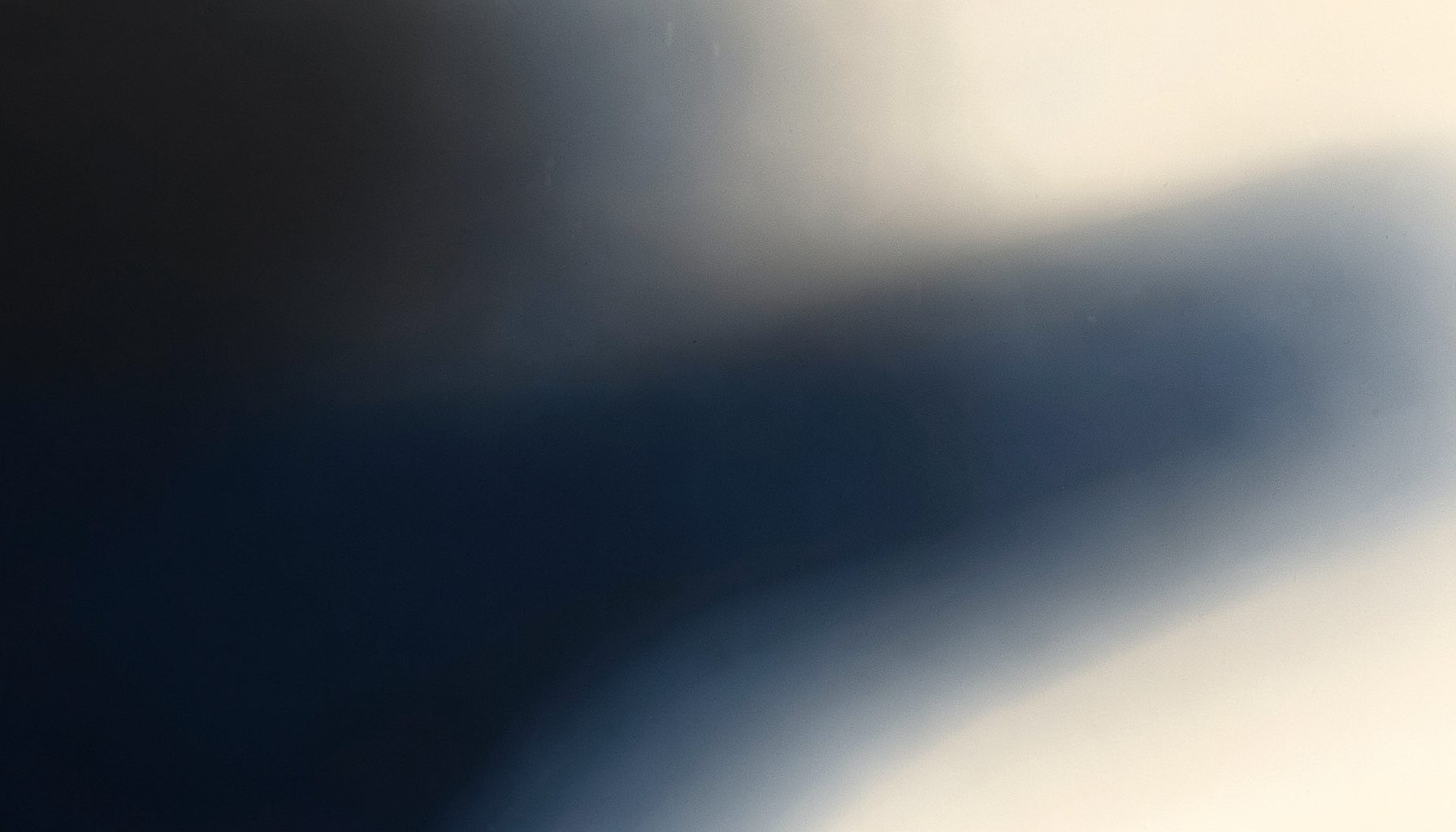 Deep charcoal and soft ivory merging in a minimalist abstract composition with subtle textural depth